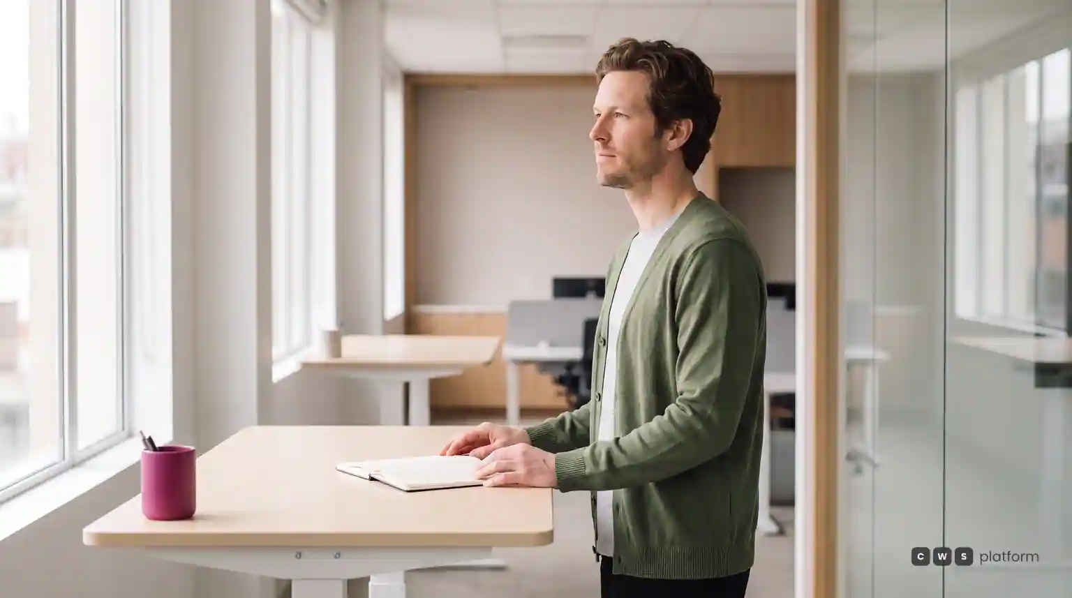 Technology leader standing at a high desk in a bright office, reviewing the architecture of a commerce platform.